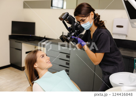 Dentist woman photographing with professional camera the result of her work in clinic 124416848