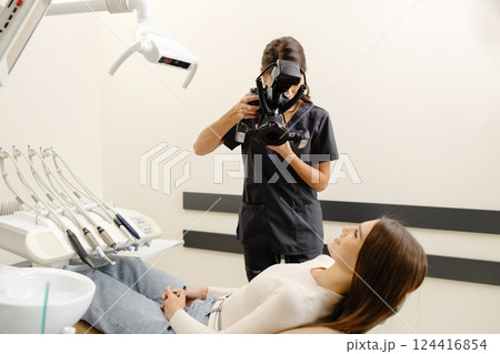 Dentist woman photographing with professional camera the result of her work in clinic Dentist woman photographing with professional camera the result of her work in clinic 124416854
