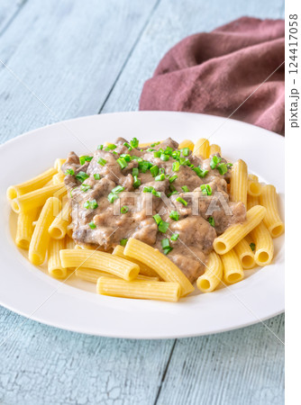 Beef stroganoff with rigatoni pasta, topped with fresh green onion garnish Beef stroganoff with rigatoni pasta, topped with fresh green onion garnish 124417058