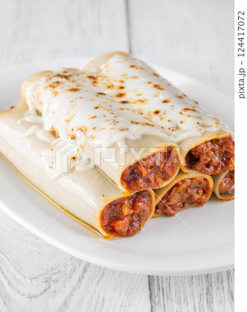 Oven-Baked Cannelloni Stuffed with Savory Bolognese and Covered in Golden Mozzarella 124417072