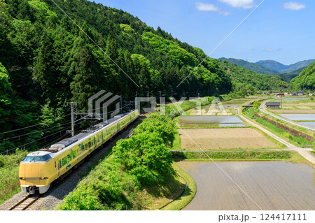 田植えの準備が進む横を城崎から大阪に急ぐ山陰本線の特急列車 124417111