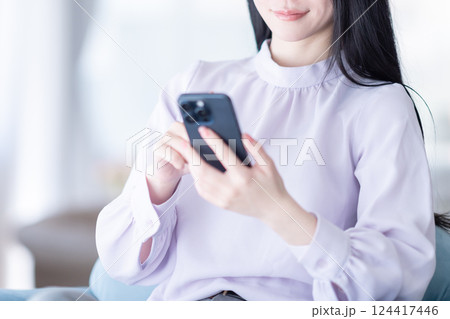 スマホでNISAで積み立てた株価を確認する若い女性 スマホでNISAで積み立てた株価を確認する若い女性 124417446