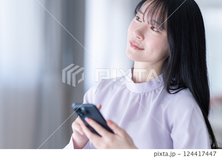 自宅でスマホを操作する若い女性 124417447