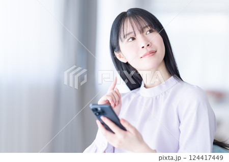 自宅でスマホを操作する若い女性 自宅でスマホを操作する若い女性 124417449