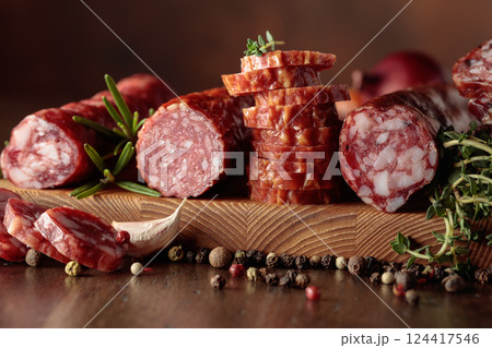 Sliced dry cured sausages with peppercorns, thyme, rosemary, and garlic. Sliced dry cured sausages with peppercorns, thyme, rosemary, and garlic. 124417546