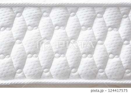 Large white mattress with stitched finishing lines. Close-up. Side view. 124417575