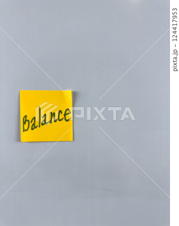 Sticky note with the word Balance written on it, affixed to white background. Illustrating themes of balance, harmony, and stability in personal and professional life. Great for concept creation 124417953