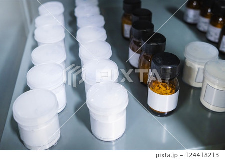 Shelf storage facility stocked with products of organized pill bottles in a modern sterile medicine factory environment Shelf storage facility stocked with products of organized pill bottles in a modern sterile medicine factory environment 124418213