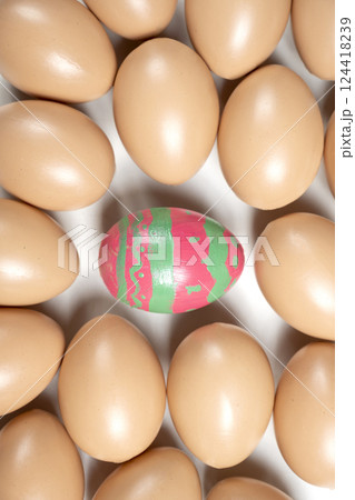 Top view of a colorful decorated easter egg surrounded by eggs on a white background. Concept of celebrating the easter holiday Top view of a colorful decorated easter egg surrounded by eggs on a white background. Concept of celebrating the easter holiday 124418239