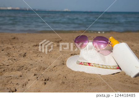 Summer beach essentials with sunglasses, sunscreen, hat Summer beach essentials with sunglasses, sunscreen, hat 124418485
