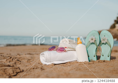 Beach accessories relaxation scene with sandals,sunglasses,hat and towel Beach accessories relaxation scene with sandals,sunglasses,hat and towel 124418488