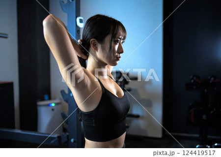 ジムで体を鍛える髪を結ぶかっこいい女性　パワーラック　ベンチプレス　筋トレ女子　 124419517
