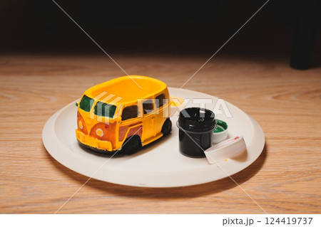 A Colorful Vintage Toy Car that has been beautifully painted, resting on a decorative plate 124419737