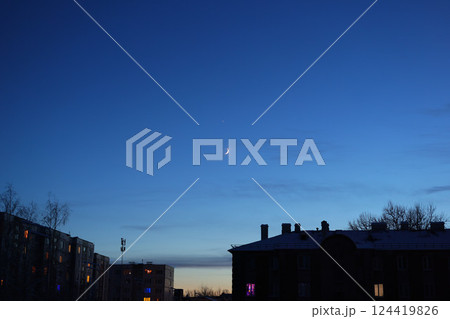 A Serene Night Sky Featuring a Beautiful Crescent Moon Glowing Over the Urban Landscape A Serene Night Sky Featuring a Beautiful Crescent Moon Glowing Over the Urban Landscape 124419826