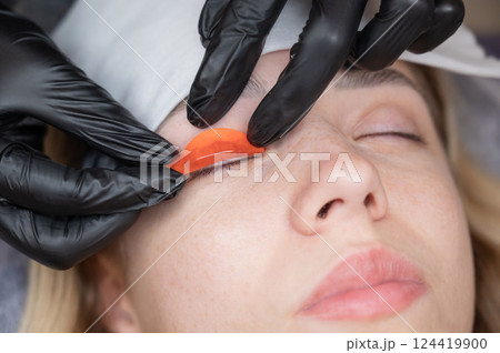 The master lays down the roller before the eyelash lamination procedure. The master lays down the roller before the eyelash lamination procedure. 124419900