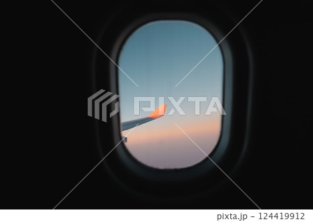 The breathtaking view from an airplane window at sunset showcasing a beautiful sky The breathtaking view from an airplane window at sunset showcasing a beautiful sky 124419912