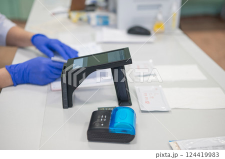 A narcologist tests urine for drugs using an electronic device.  124419983