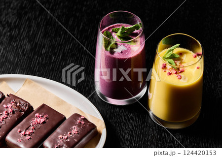 Vibrantly Colorful Smoothies and Tempting Chocolate Treats Beautifully Set on a Dark Background Vibrantly Colorful Smoothies and Tempting Chocolate Treats Beautifully Set on a Dark Background 124420153