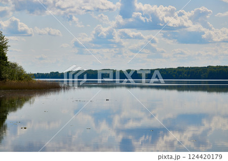 Serene Reflection on a Beautiful and Tranquil Lake Under Bright and Fluffy Clouds 124420179