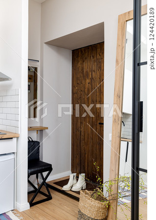 A modern entryway featuring a wood accent combined with a minimalist design aesthetic 124420189