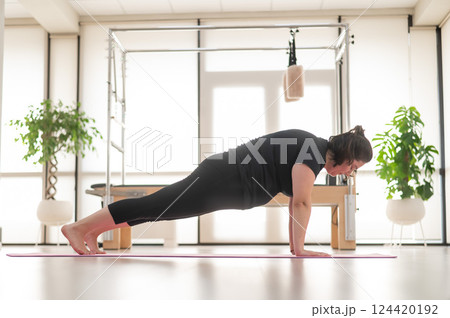 Fat woman doing yoga in studio. Fat woman doing yoga in studio. 124420192