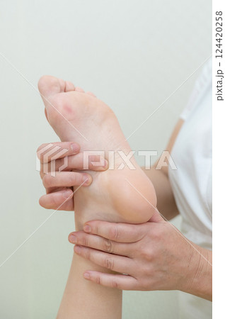 Close up of a woman's foot being massaged. Close up of a woman's foot being massaged. 124420258