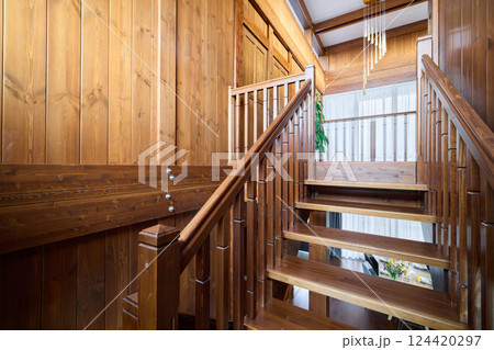 An Elegant Wooden Staircase Bathed in Beautiful Natural Light Creates a Warm Atmosphere An Elegant Wooden Staircase Bathed in Beautiful Natural Light Creates a Warm Atmosphere 124420297