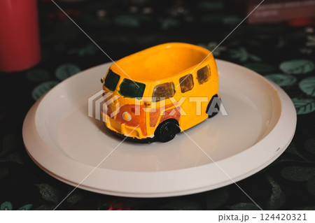 A Delightful and Colorful Yellow Bus Figurine Displayed Beautifully on a Decorative Plate A Delightful and Colorful Yellow Bus Figurine Displayed Beautifully on a Decorative Plate 124420321