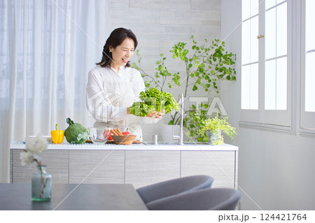 キッチンで料理をするミドル女性 124421764