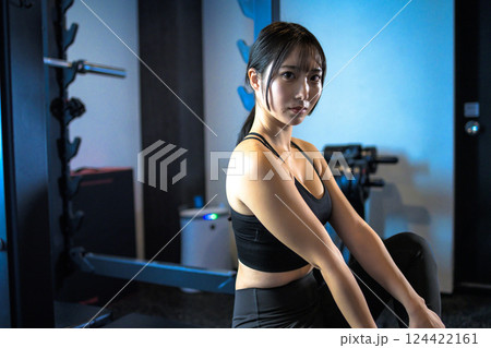ジムで体を鍛えるためパワーラックの前に座るかっこいい女性　ベンチプレス　筋トレ女子　 124422161