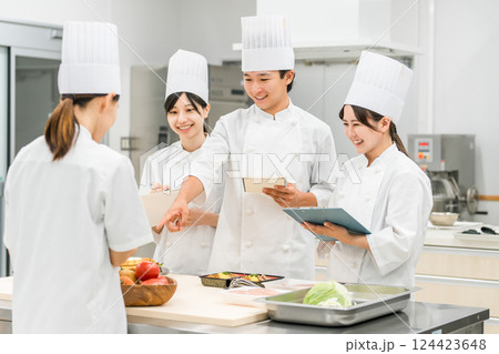 調理師のセミナー・専門学校・社員教育で教える講師の女性と生徒の男女（外食産業） 124423648