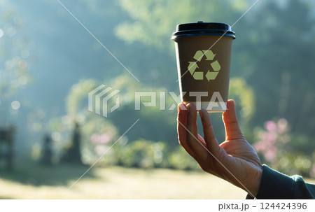 eco living, environment and sustainability concept. Hand holding recycle symbol on green bokeh background. eco and save the earth concept. Save the planet and energy concept. 124424396