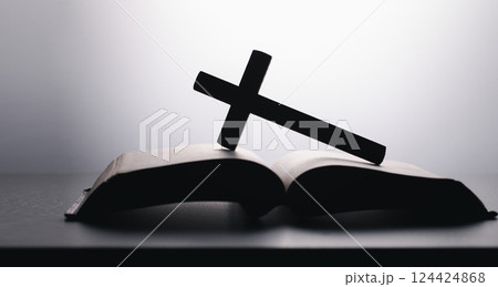 Bible with wooden cross on White Background. Holy book. Black and white photography. wooden cross over opened bible on wooden table 124424868