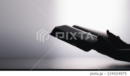 Hands in prayer on holy bible in church concept for faith, spirituality and religion. Unrecognizable woman holding a bible in her hands and praying. Hands clasped in prayer over holy bible. 124424975