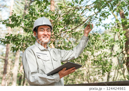 公園・森林で樹木をチェックする作業着姿の林業の男性 124424981