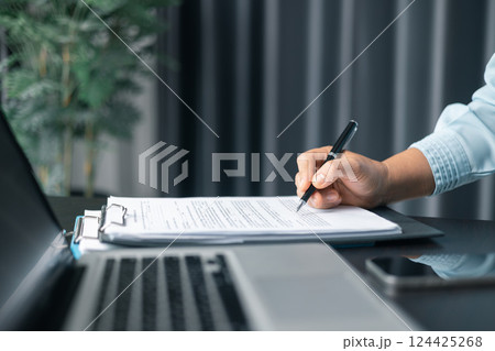 Close up businesswoman signing documents. Hand of woman write business document charts at office desk. Woman signing document, focus on female hand holding pen, putting signature at official paper. Close up businesswoman signing documents. Hand of woman write business document charts at office desk. Woman signing document, focus on female hand holding pen, putting signature at official paper. 124425268