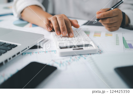 Business financing accounting banking concept. Businesswoman hand doing finances and calculate on desk about cost at home office. Woman working on desk with using calculator, finance accounting. Business financing accounting banking concept. Businesswoman hand doing finances and calculate on desk about cost at home office. Woman working on desk with using calculator, finance accounting. 124425350