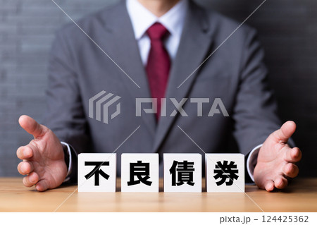 不良債権のブロックとスーツを着たミドル男性ビジネスマン 124425362