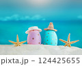 Blue and pink eggs in hats with starfish on the sand of the beach, beyond the sea. Easter in hot countries. Copy space 124425655