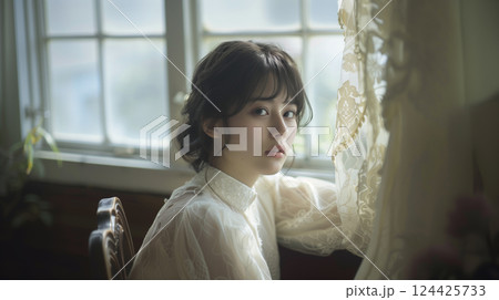 レースのカーテン越しに光を受ける女性のポートレート（美容・広告：AI生成） 124425733