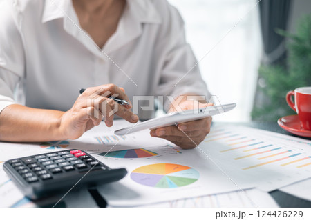 Businesswoman working on desk office with using a calculator to calculate the numbers, finance accounting concept. Woman accountant use calculator and computer. tax, accounting, statistics Businesswoman working on desk office with using a calculator to calculate the numbers, finance accounting concept. Woman accountant use calculator and computer. tax, accounting, statistics 124426229