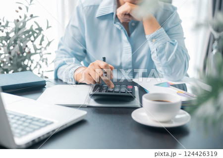 Female entrepreneur working in home office at her desk. Business woman entrepreneur in office using laptop at work, professional middle aged female company executive working on computer at workplace. 124426319