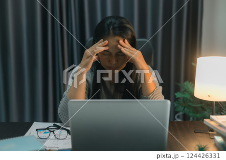 Depression at work. Asian Businesswoman sitting and working hard at with front of computer and lots of documents on table in workplace at late with serious action, Work hard and too late concept Depression at work. Asian Businesswoman sitting and working hard at with front of computer and lots of documents on table in workplace at late with serious action, Work hard and too late concept 124426331