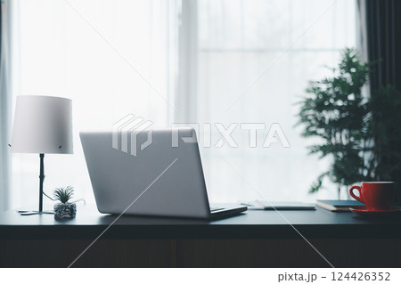 Office workplace with laptop and smart phone on wood table. Workspace, desktop computer, office supplies, houseplant and books at office. desk work concept. laptop Comfortable work table in office. Office workplace with laptop and smart phone on wood table. Workspace, desktop computer, office supplies, houseplant and books at office. desk work concept. laptop Comfortable work table in office. 124426352