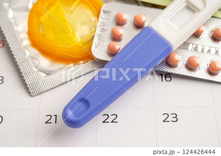 Pregnancy test and birth control pills on calendar, contraception health and medicine. 124426444