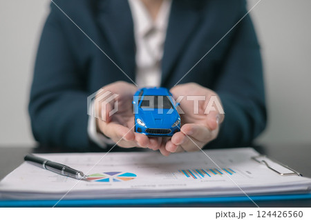 Agent facilitated a business deal, finalizing the agreement for automobile insurance to protect the vehicle during transport. car insurance concept. Agent facilitated a business deal, finalizing the agreement for automobile insurance to protect the vehicle during transport. car insurance concept. 124426560