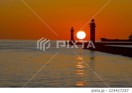 姫路港の紅白灯台の真ん中に沈みゆくだるま夕陽 124427287