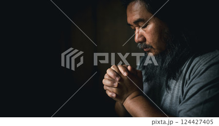 Person man, turned to God in prayer, demonstrating their religious faith and devotion through worship. Man hand in prayer, expressing his religious faith in God through worship of Jesus Christ. 124427405