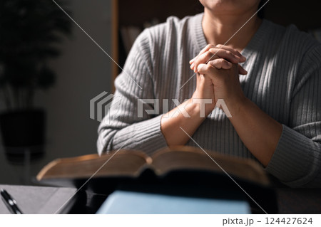 Woman with Bible in her hand, her faith unwavering as she prayed and worshiped God, finding strength and guidance in her Christian religion through the holy book. pray, woman, bible, faith, religion. 124427624