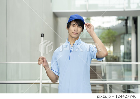 カメラ目線で笑顔の若い男性クリーニングスタッフ カメラ目線で笑顔の若い男性クリーニングスタッフ 124427746